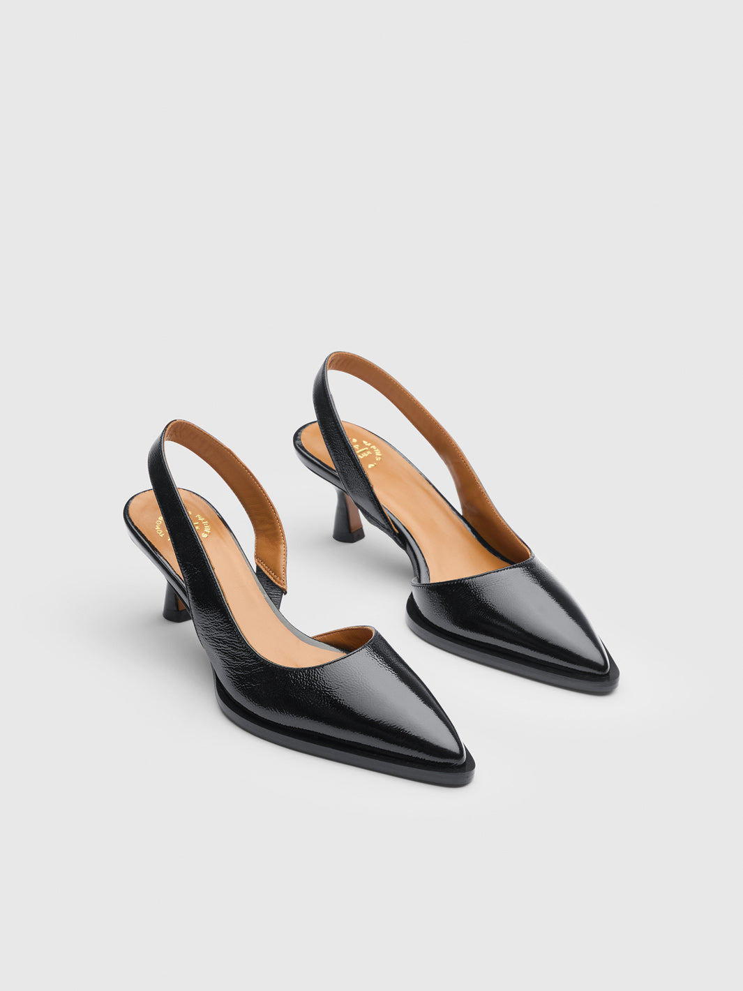 A pair of black pointed-toe slingback pumps with kitten heels, shown on a light gray background.