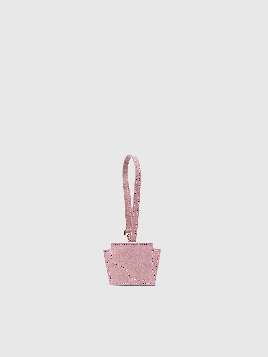A small light pink suede keychain with a matching wrist strap and a small gold-tone metal clasp, centered on a light gray background.