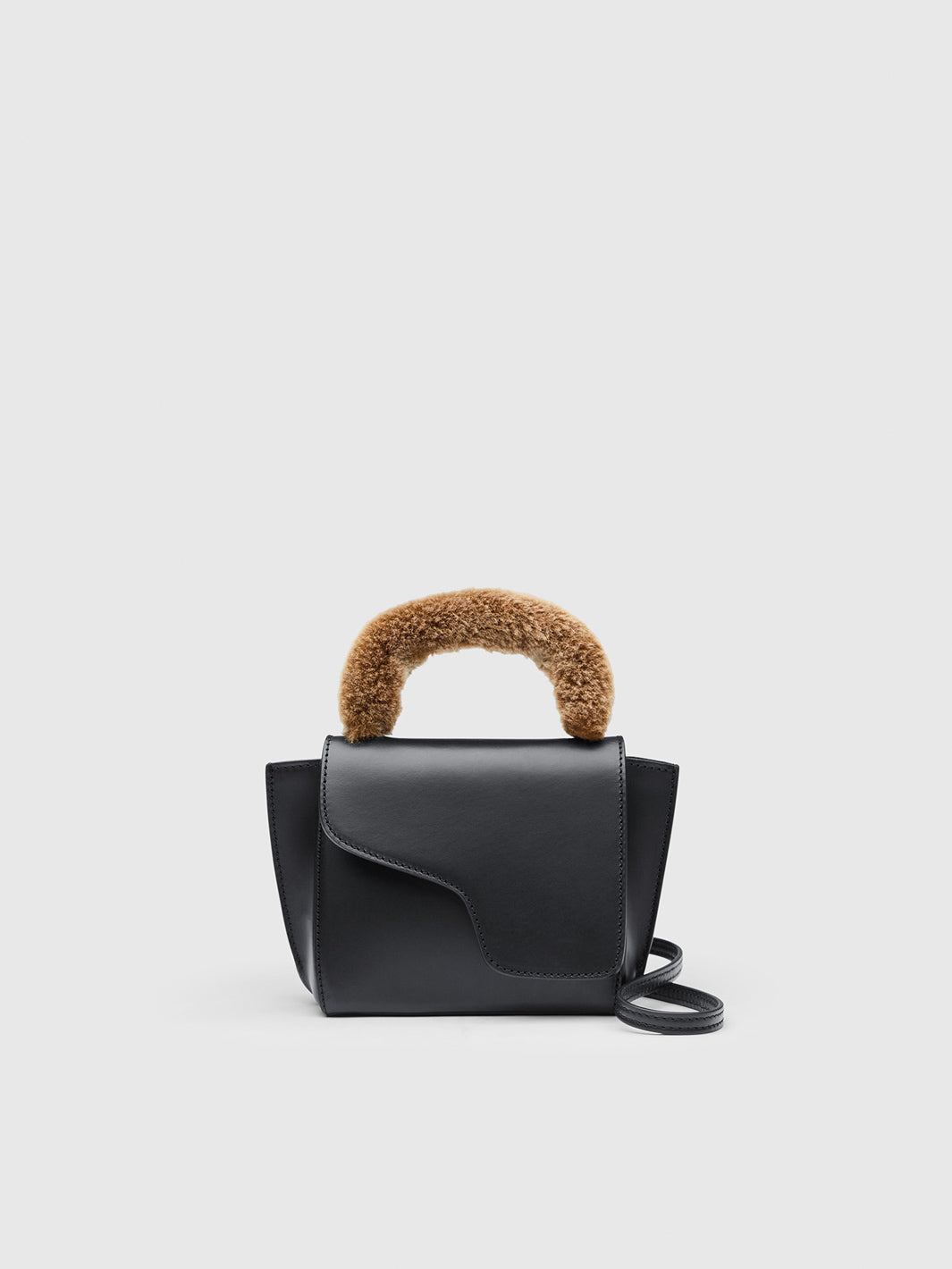 A black leather handbag with a curved, fluffy brown handle, shown against a light gray background.