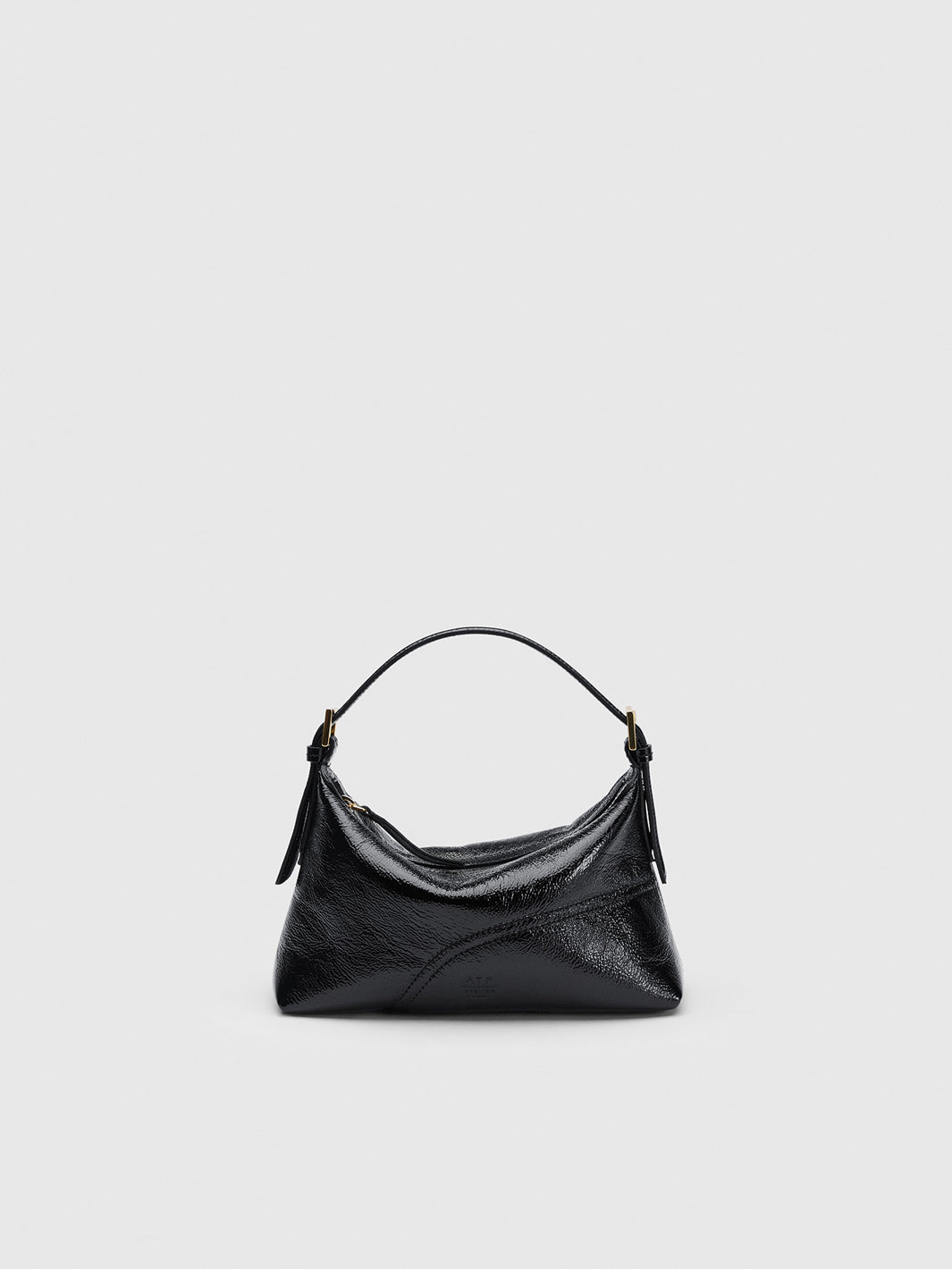 A black textured leather hobo handbag with a single top handle and tassel details, photographed against a solid light gray background.