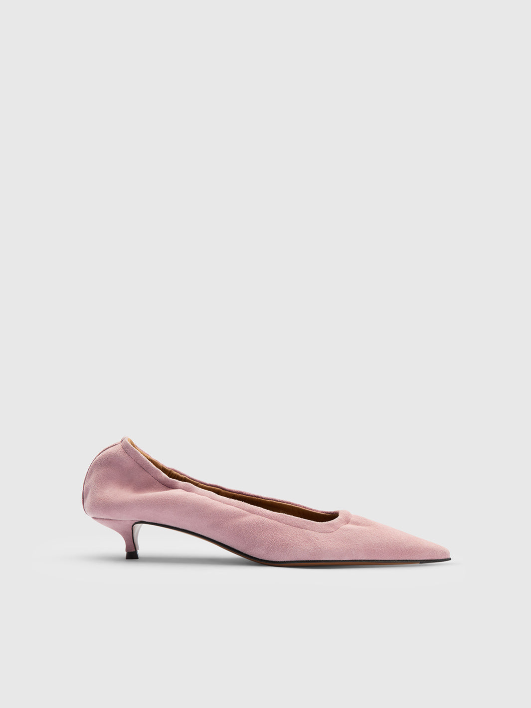 A dusty pink pointed-toe pump set against a light gray studio background.